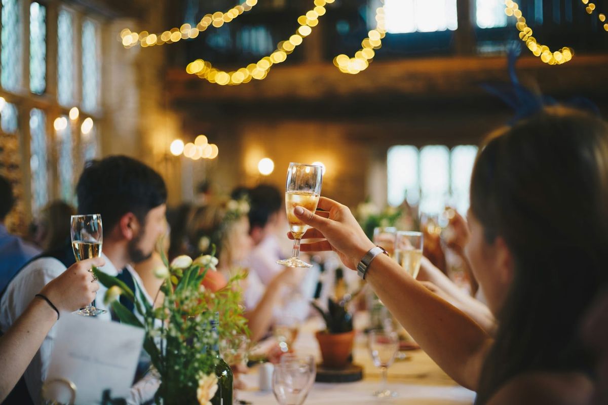 Guests raising a toast at a long dinner table